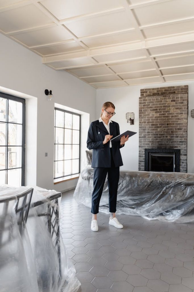 pexels-photo-7415124 Real estate agent in a suit reviewing paperwork inside a newly renovated home.